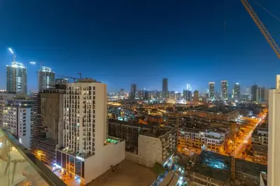 a view of a city at night with buildings at FIRST CLASS 1BR Luxurious JVC Blissful Escape in Dubai
