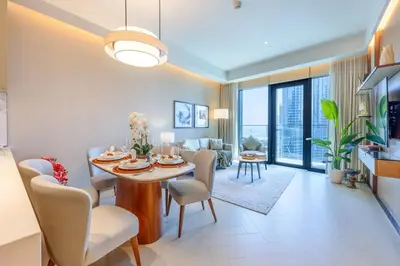 a dining room and living room with a table and chairs at Address Dubai Opera Residence with Burj Khalifa Views in Dubai