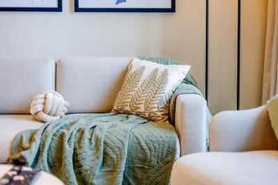 a couch with a blanket and a teddy bear on it at Address Dubai Opera Residence with Burj Khalifa Views in Dubai