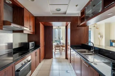a kitchen with wooden cabinets and a counter top at GuestReady - Stunning Burj View | Near Dubai Mall in Dubai