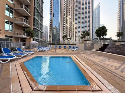a swimming pool with lounge chairs and a building at GuestReady - Stunning Burj View | Near Dubai Mall in Dubai