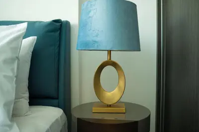 a lamp sitting on a table next to a bed at AWS Holiday Homes - Modernity with a View in Dubai