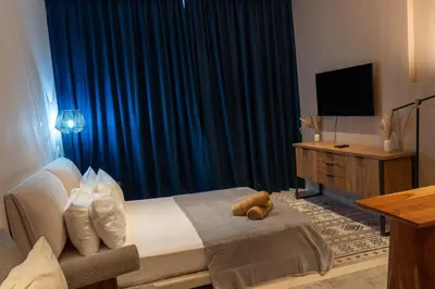 a bedroom with a bed with a teddy bear on it at Chic Studio with Beach & Rooftop Pool Access in Dubai