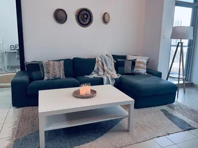 a living room with a blue couch and a table at COZY 1BD in Dubai Marina in Dubai