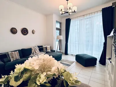 a living room with a blue couch and a tv at COZY 1BD in Dubai Marina in Dubai