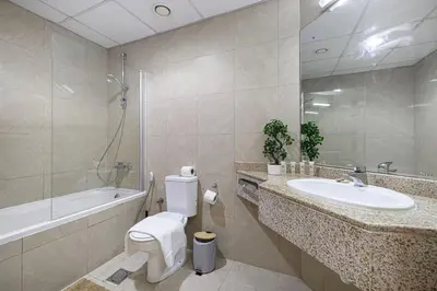 a bathroom with a toilet and a sink and a tub at Amazing Palm View - Prime Location - Spacious in Dubai