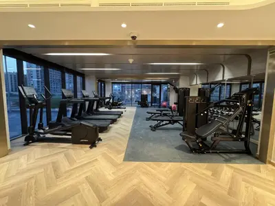 a gym with a row of treadmills and machines at DiSalvo Luxury Studio in Azizi riviera 67 in Dubai