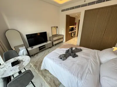 a bedroom with a large white bed and a television at DiSalvo Luxury Studio in Azizi riviera 67 in Dubai