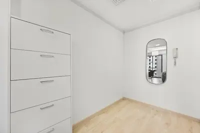 a kitchen with white cabinets and a mirror at 3 Bed Spacious JBR Modern Living Holiday Home in Dubai