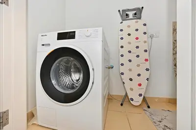 a washing machine and a snowboard in a room at 3 Bed Spacious JBR Modern Living Holiday Home in Dubai