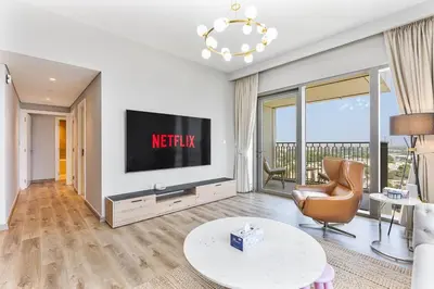 a living room with a television and a couch and a chair at Bright 2BR APT Near The Burj Khalifa and Dubai Mall in Dubai