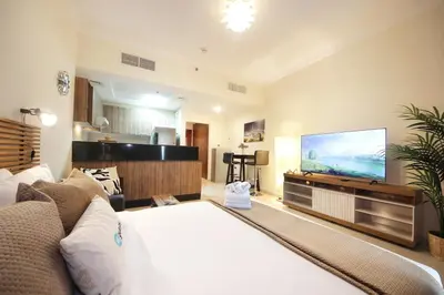 a living room with a bed and a flat screen tv at HiGuests - Chic Studio in Downtown Dubai in Dubai