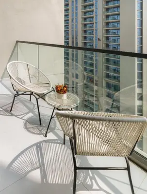 a balcony with two chairs and a table and some buildings at Aykon Tower - Studio Apartment - Allsopp & Allsopp in Dubai