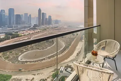 a balcony with two chairs and a view of a city at Aykon Tower - Studio Apartment - Allsopp & Allsopp in Dubai