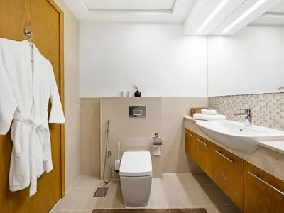 a bathroom with a white toilet and a sink at Downtown 1BR Pool with Burj Khalifa View Near Dubai Mall in Dubai