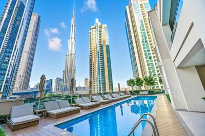 a hotel pool with chairs and a view of the city at 28th Floor Apartment Next to Burj And Mall Sleeps 7 in Dubai