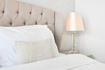 a bedroom with a white bed and a lamp at 28th Floor Apartment Next to Burj And Mall Sleeps 7 in Dubai