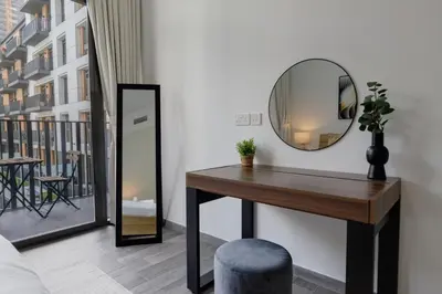 a mirror and a table in a room with a balcony at Belgravia Square, JVC - 1 Bedroom Apartment - Allsopp & Allsopp in Dubai