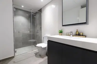 a bathroom with a toilet and a sink and a shower at Belgravia Square, JVC - 1 Bedroom Apartment - Allsopp & Allsopp in Dubai
