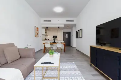 a living room with a couch and a table at Belgravia Square, JVC - 1 Bedroom Apartment - Allsopp & Allsopp in Dubai