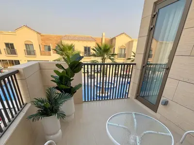 a balcony with two palm trees and a building at Luxury 3BR Villa with Pool View & Modern Comfort in Dubai