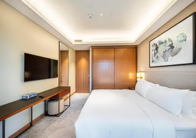 a bedroom with a large white bed and a television at Luxury 2BR at Address Opera with Burj Khalifa View in Dubai