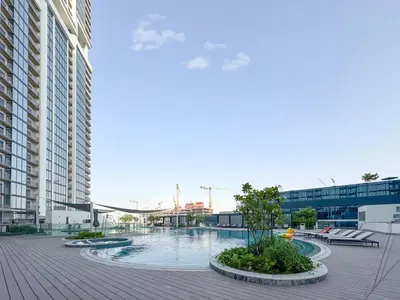 a large swimming pool in a city with buildings at Trophy - Modern 2BR in Crest Tower in Dubai