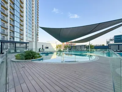 a building with a deck with a large umbrella on it at Trophy - Modern 2BR in Crest Tower in Dubai
