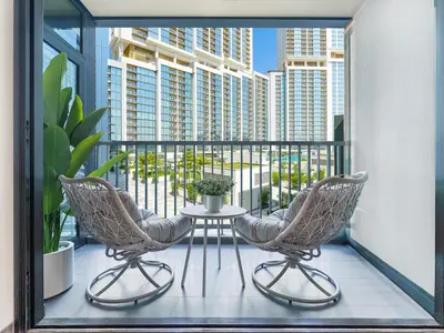 a balcony with two chairs and a table on a balcony at Trophy - Modern 2BR in Crest Tower in Dubai