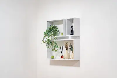 a white wall mounted shelf with a plant in it at Escape24 Spacious 1BR with Pool View, JVC in Dubai