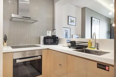 a kitchen with a sink and a microwave at Paramount Luxe Suite, Business Bay in Dubai