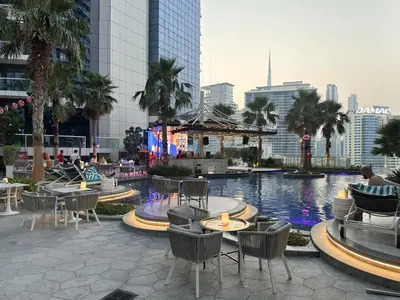 a pool with chairs and tables in a city at Paramount Luxe Suite, Business Bay in Dubai