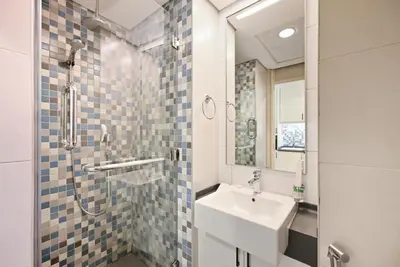 a bathroom with a sink and a shower at Amazing Views of Palm & Dubai Eye Stylish Studio in Dubai