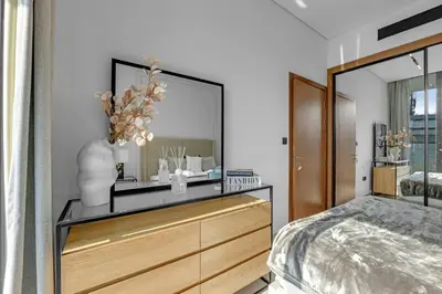 a bedroom with a dresser with a large mirror at Modern Luxe | Heart of Dubai | Trillionaire Living in Dubai
