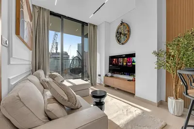 a living room with a couch and a tv at Modern Luxe | Heart of Dubai | Trillionaire Living in Dubai
