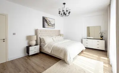 a white bedroom with a bed and a mirror at Stylish 2-Bedroom Apartment with Marina View JBR in Dubai