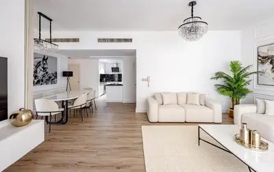 a white living room with a white couch and a table at Stylish 2-Bedroom Apartment with Marina View JBR in Dubai