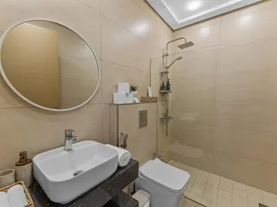 a bathroom with a sink and a mirror and a toilet at Convenient City Apartment Near Metro & Downtown in Dubai