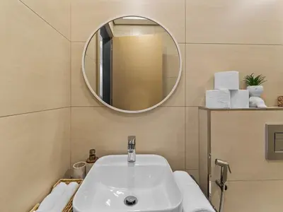 a bathroom with a white sink and a mirror at Convenient City Apartment Near Metro & Downtown in Dubai