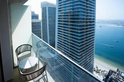 a balcony with two chairs and a view of the ocean at Palace Beachfront Dubai Harbour in Dubai