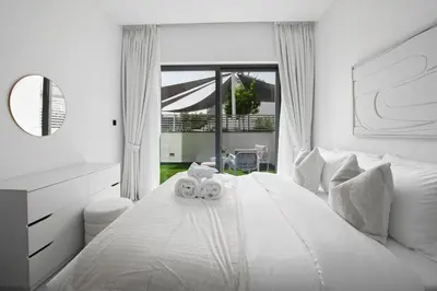 a white bedroom with two teddy bears on a bed at Modern Stay at The Crest Tower Near Meydan with Pool and Sauna in Dubai