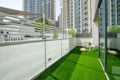 a balcony with green grass on a building at Modern Stay at The Crest Tower Near Meydan with Pool and Sauna in Dubai