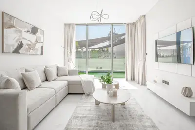 a white living room with a couch and a table at Modern Stay at The Crest Tower Near Meydan with Pool and Sauna in Dubai