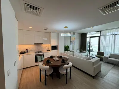 a kitchen and living room with a table and a couch at Luxury two beds apartment in Dubai
