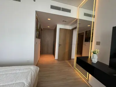 a bedroom with a bed and a large mirror at Luxury two beds apartment in Dubai
