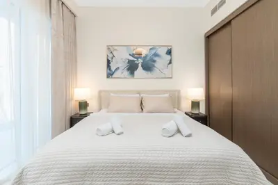 a bedroom with a large white bed with two pillows at Beachfront Luxe 1BR Grand Bleu with Private Beach & Sea View in Dubai
