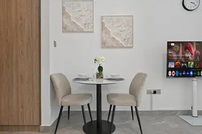 a table with two chairs and a vase on it at Deluxe Studio for 2 in Peninsula One, Business Bay in Dubai