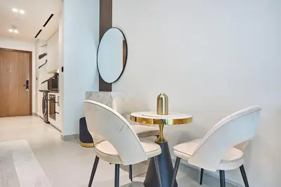 a dining room with a table and chairs and a mirror at Glamorous Trillionaire Living in Dubai
