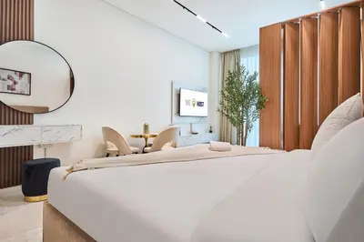 a white bedroom with a large bed and a mirror at Glamorous Trillionaire Living in Dubai