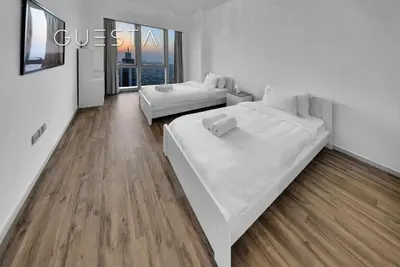 a white room with two beds and a couch at Grande Tower by Emaar, Downtown, Burj Khalifa in Dubai